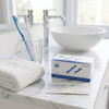 Alcohol Wipes 100 Pack box and two 70% isopropyl alcohol pad sachets on a white marble bathroom vanity